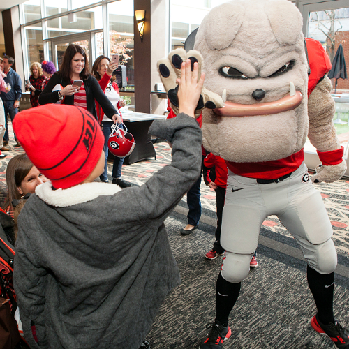 The UGA Experience at the Georgia Center. Hairy Dawg giving a kid the high five at the Georgia Center Lobby